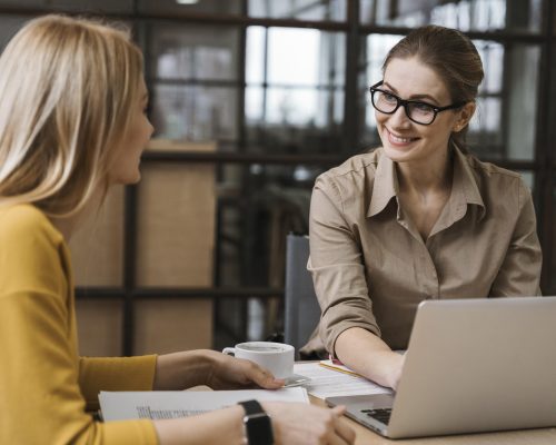 smiley-businesswomen-working-with-laptop-desk